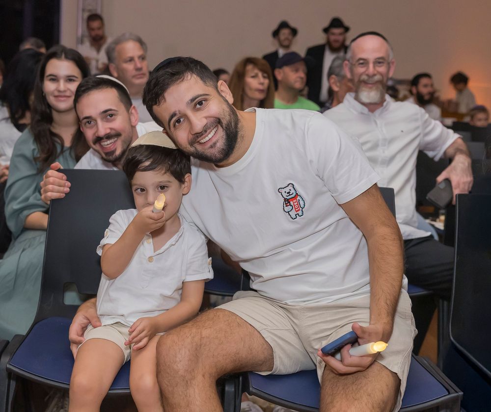 A group of people sitting together in an audience, smiling and enjoying an event.