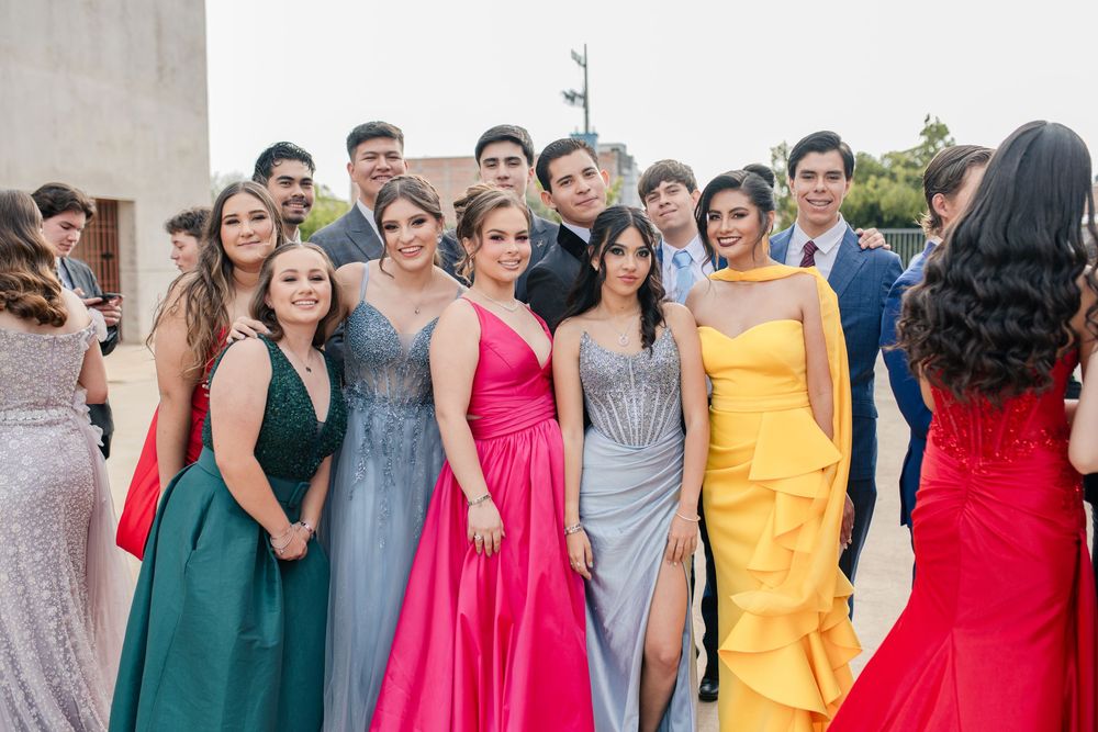 Wedding party lineup showing diverse formal dresses in yellow, red, green and pink tones.