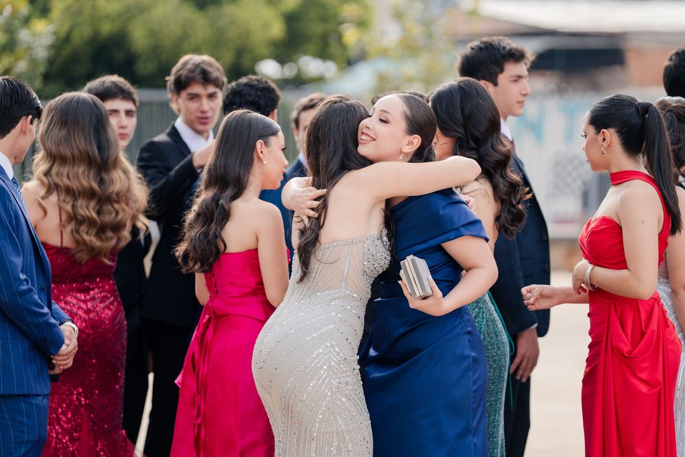 Wedding party members in formal attire posing together at an outdoor venue.