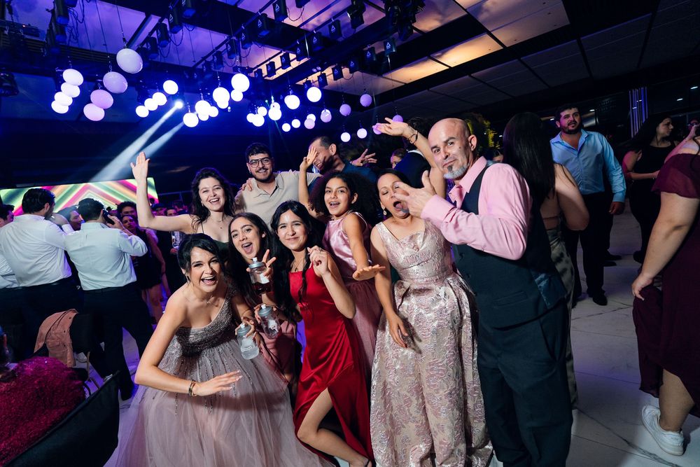 Lively party scene with disco lights illuminating a crowded dance floor in blue and purple hues.