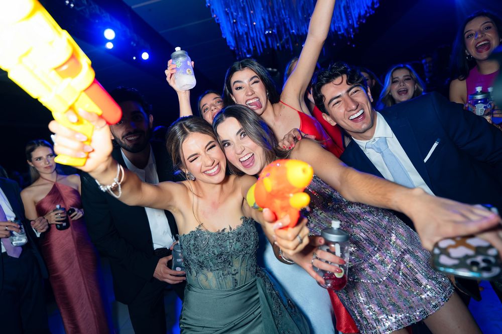 Festive party atmosphere with guests dancing under blue stage lighting and disco effects.