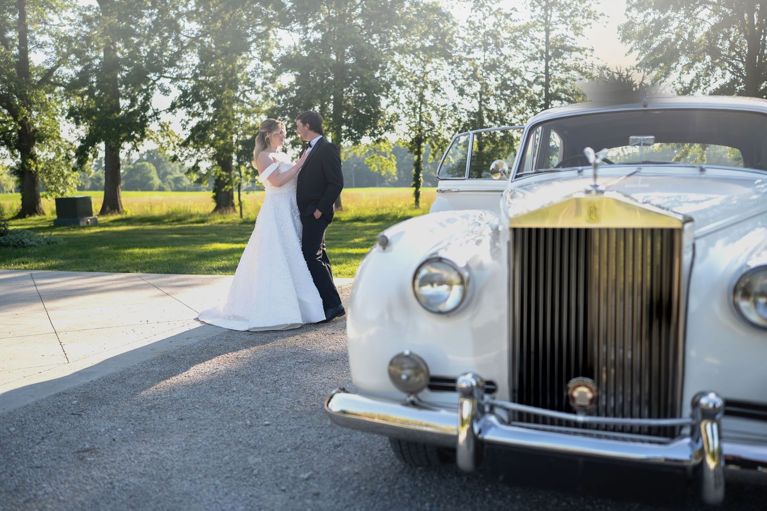 Classic white Rolls Royce wedding car parked in front of elegant venue.