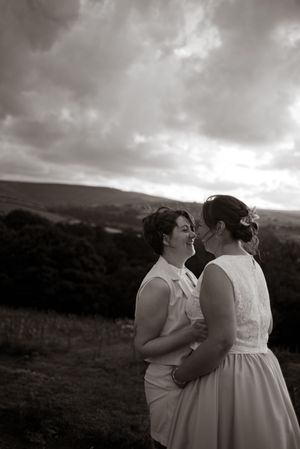 two brides laughing with each other on their wedding day. black and white image. LGBT wedding photography