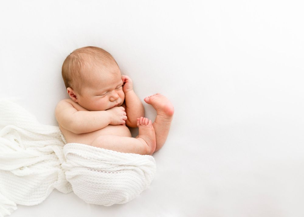classic newborn curled up pose on beanbag for baby pictures