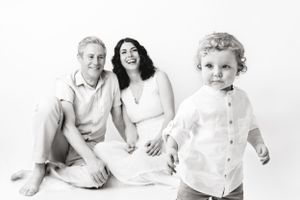 parents smile as their one year old toddles through the studio