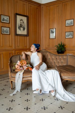Wedding dress displayed in wood-paneled room with vintage decor.