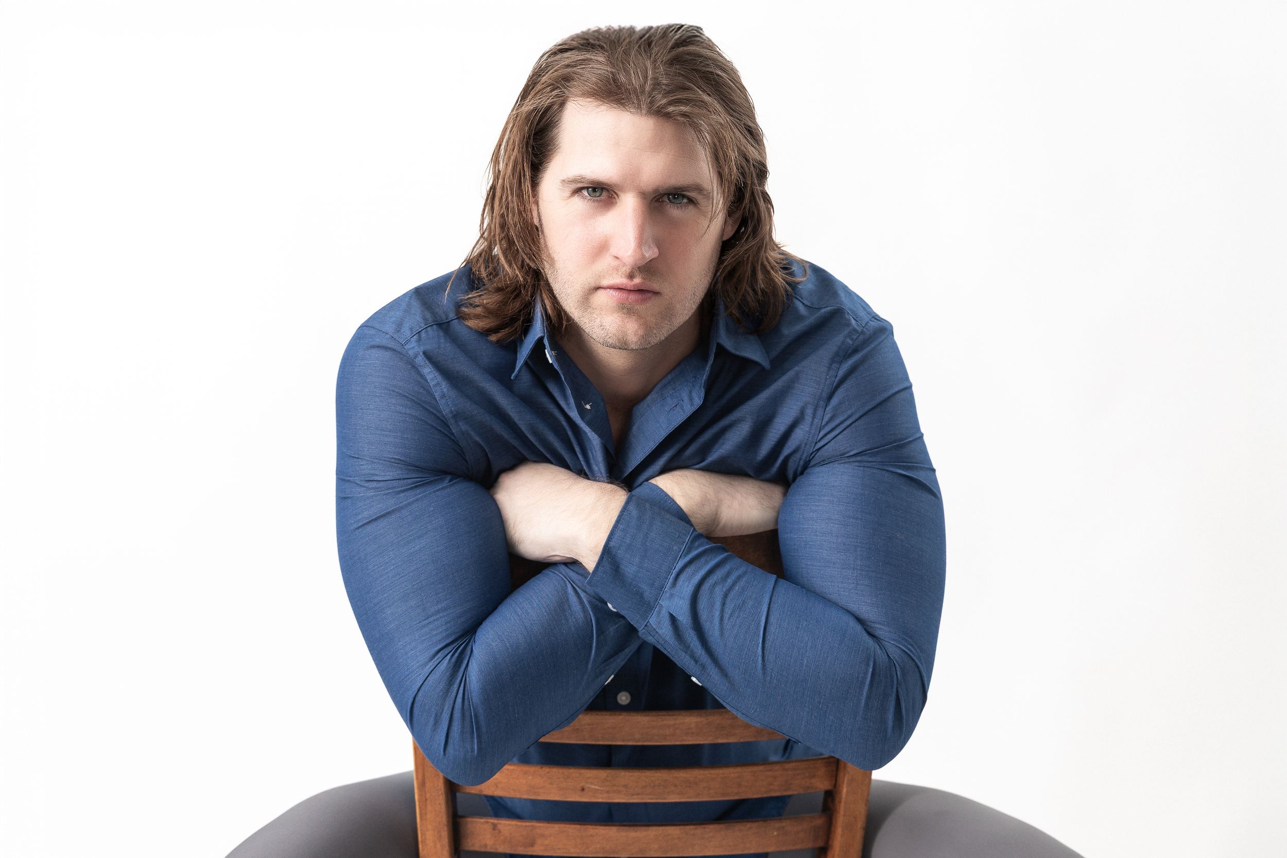 Three photos of someone wearing a navy blue sweater posing with crossed arms against a white backdrop.