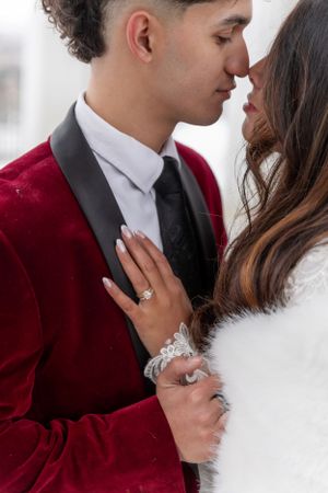 Cora Emilie Media -Close-up wedding photography showing tender moments between newlyweds in burgundy and white attire.