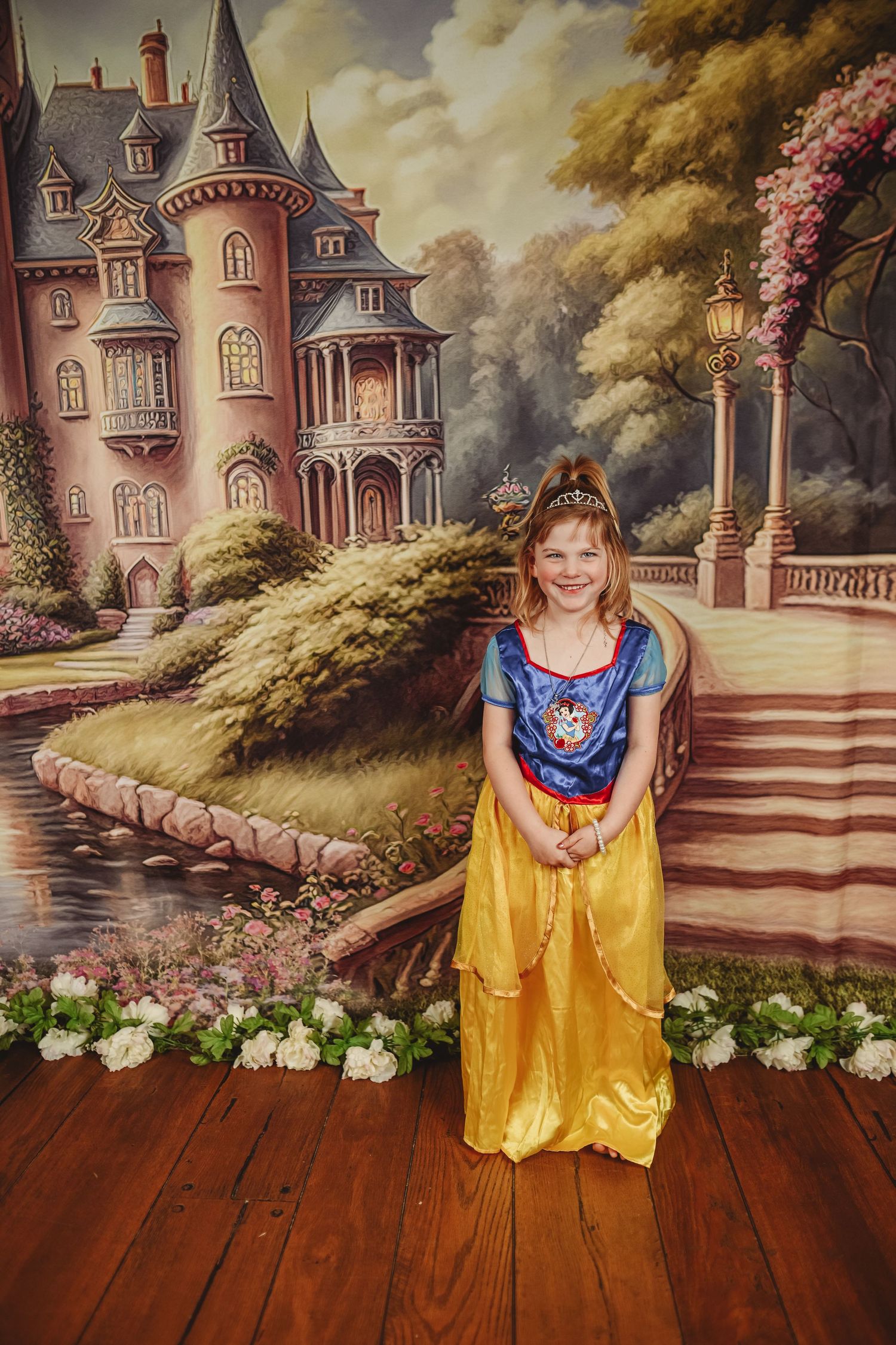 Fantasy photo session with a castle backdrop and yellow princess dress.
