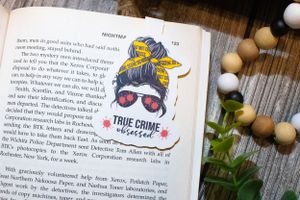Open book pages with decorative stickers including a true crime themed design.