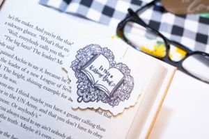 Book pages with ornate frame stickers and decorative elements in black and white.