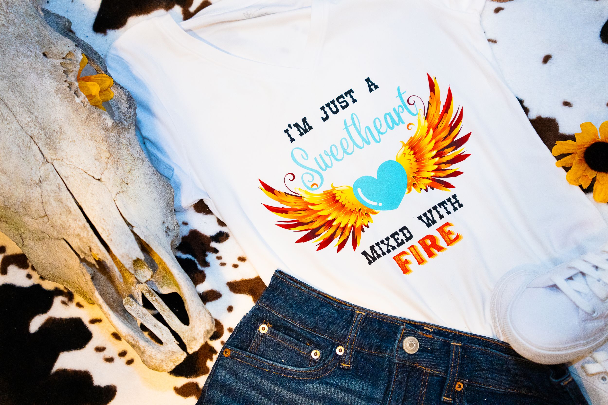 White t-shirts featuring phoenix and bird designs with inspirational messages.