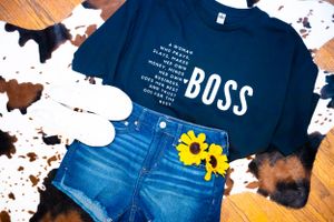 Navy blue t-shirts with white text designs displayed against speckled background.