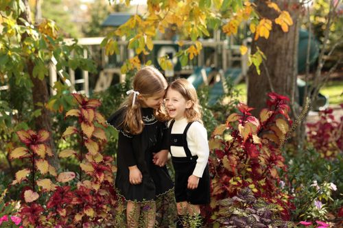 sibling share a sweet moment surrounded by vibrant flowers in Jackson, NJ