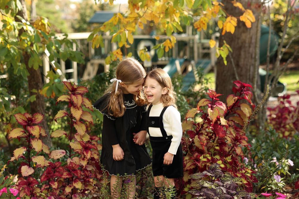 sibling share a sweet moment surrounded by vibrant flowers in Jackson, NJ