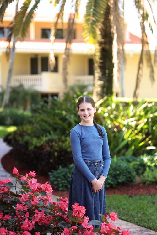 teen, bas mitzvah girl posing in a pretty, vibrant garden
