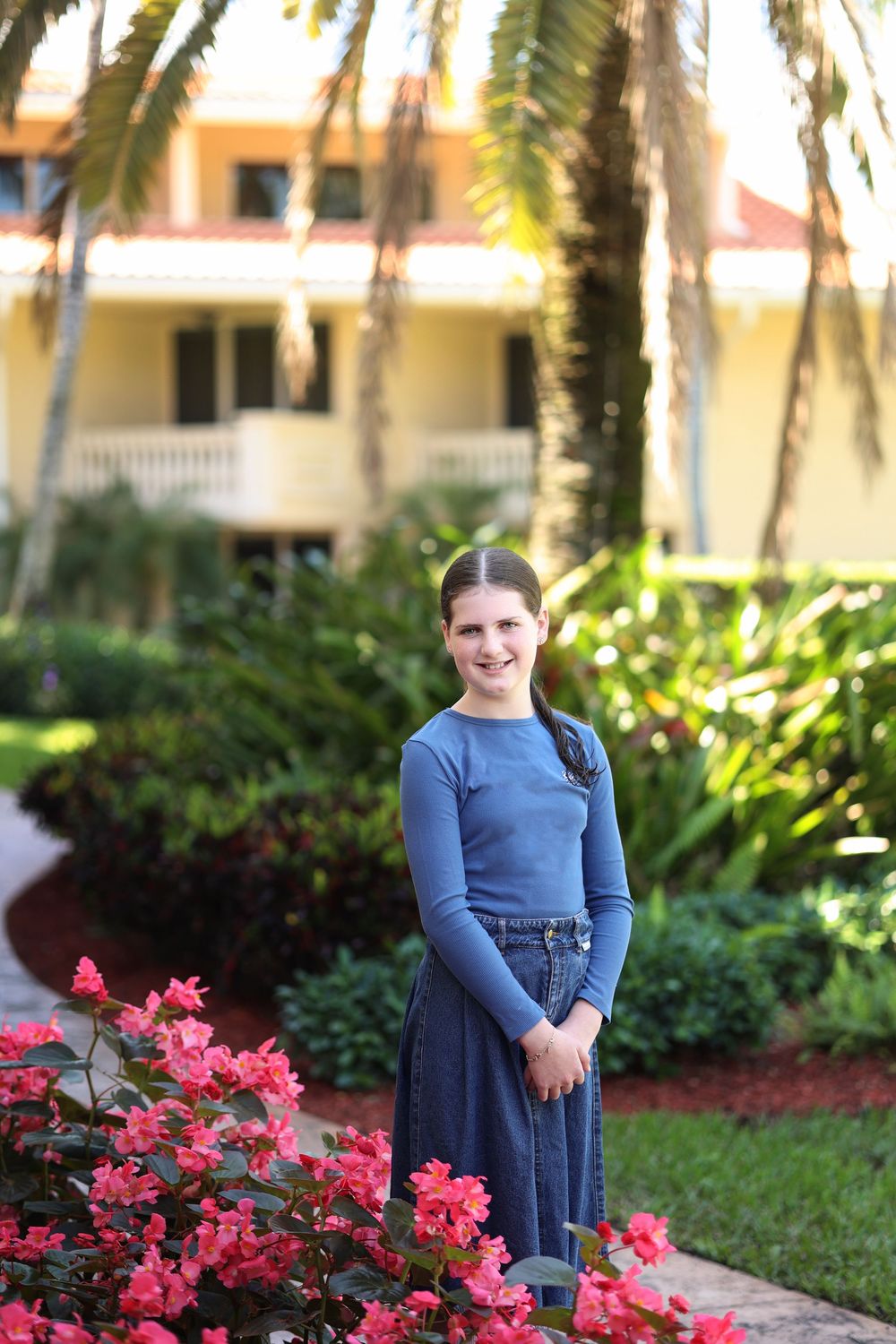 teen, bas mitzvah girl posing in a pretty, vibrant garden