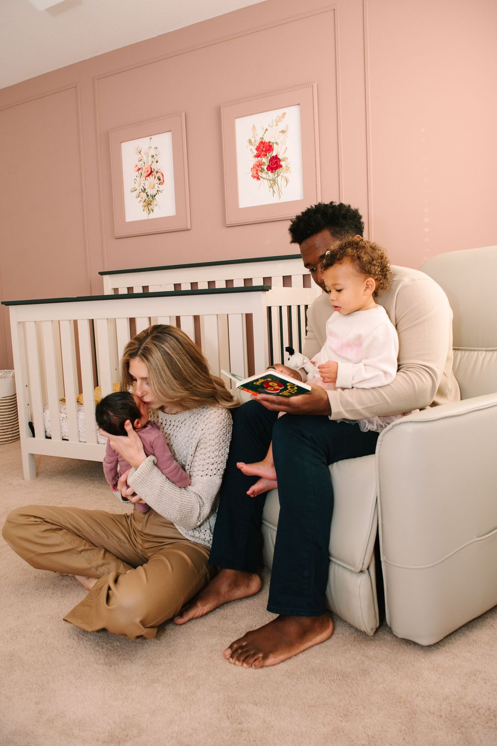 A couple relaxes together on the floor against a couch while reading books in a cozy room setting.