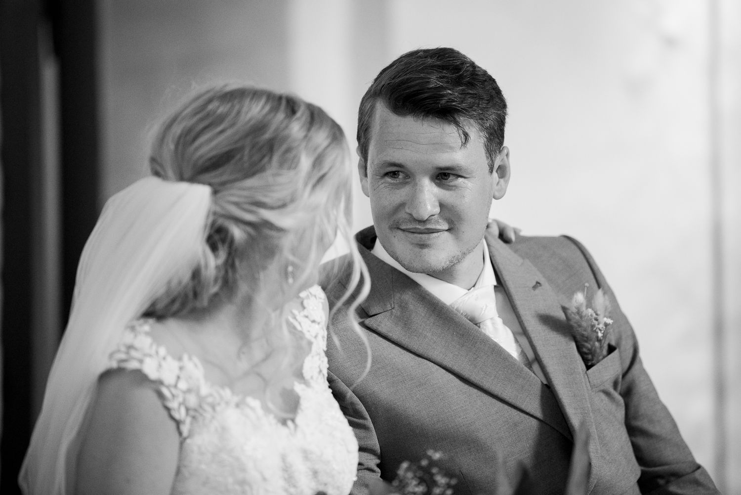 Black and white wedding portrait capturing an intimate moment between bride and groom.