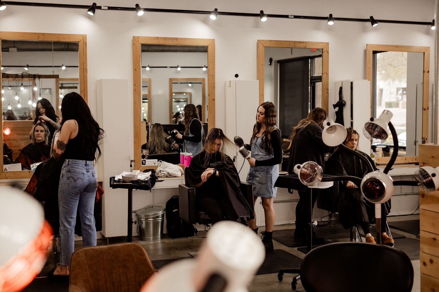 An action photo of three salon stylists working on their clients hair for a branding session.