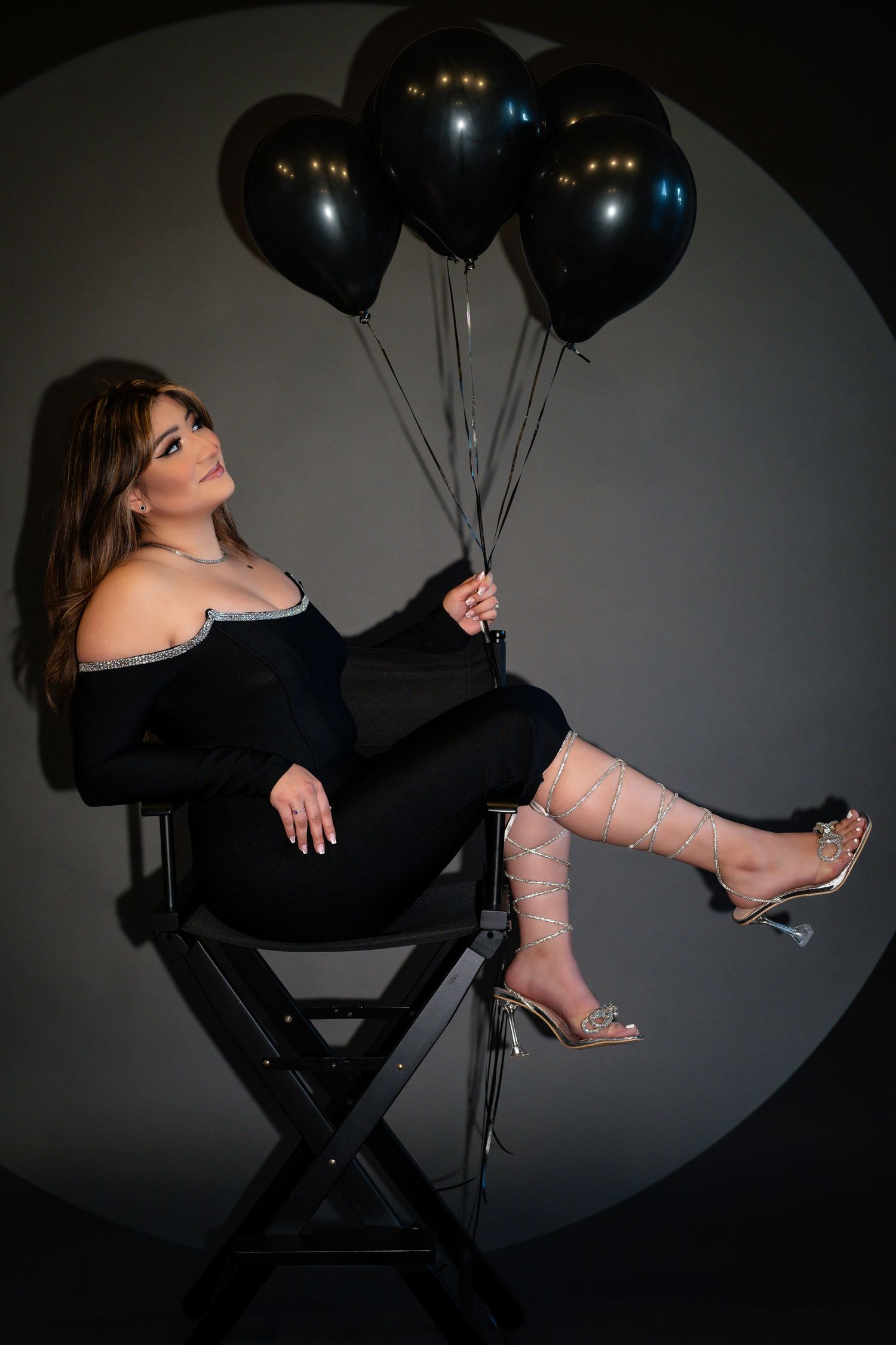 Dramatic photoshoot with black balloons showing poses in formal black attire.