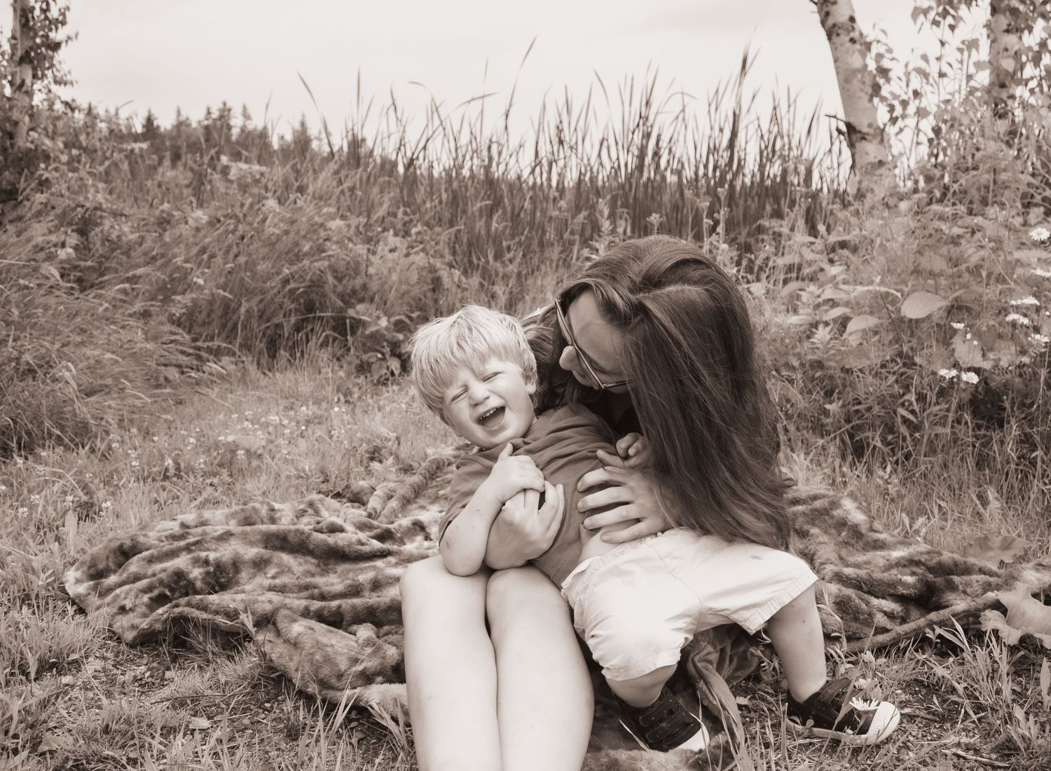 mom and little boy laughing, mom tickling him, candid, real, emotive motherhood, strong bond between mom and child.