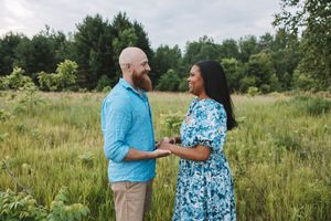 Couple holding hands in a grassy field during a relaxed outdoor couples photo session