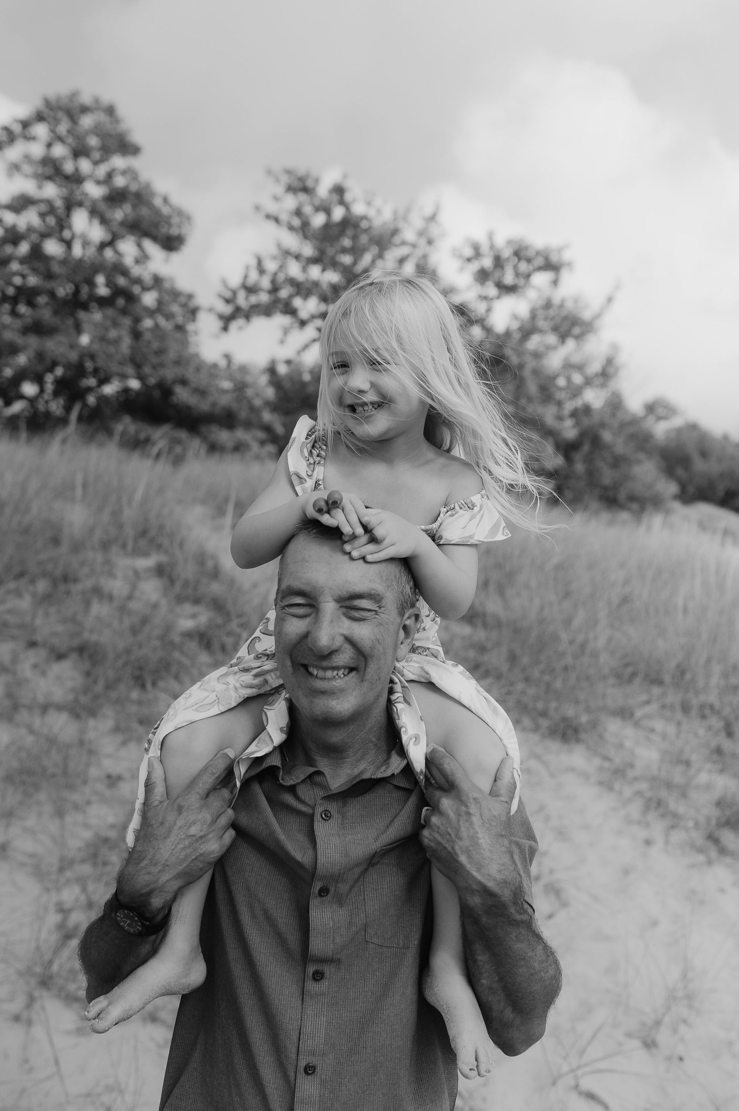 Black and white portrait of joyful piggyback ride between father and daughter.