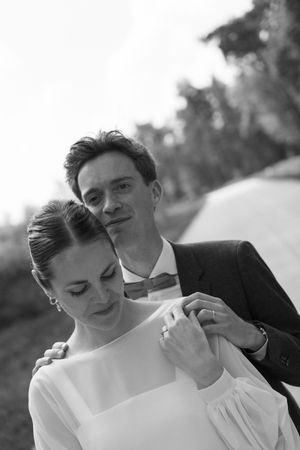 Black and white portrait of a couple in wedding attire sharing an intimate moment.