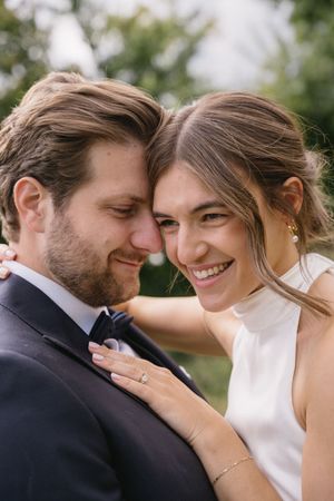 An intimate close-up of a couple sharing a tender moment in wedding attire.
