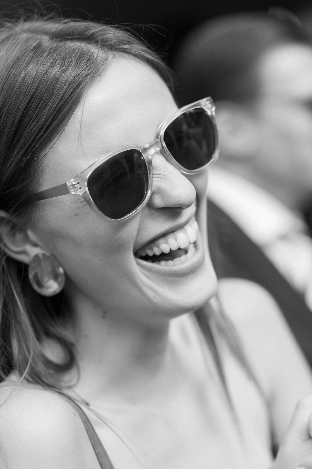Black and white portrait showing joyful laughter with sunglasses.