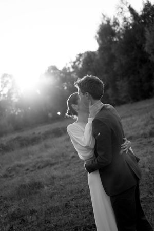 Romantic black and white wedding photos captured at sunset with natural backlighting.