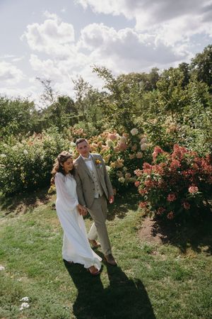 Couple dancing playfully in a beautiful rose garden on a sunny afternoon.