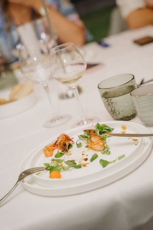 Elegant plated dishes with garnished food on a formal dining table.