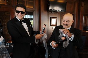 A group of people in formal black suits and sunglasses pose in a cinematic style reminiscent of action movies.