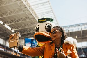 Oregon Duck mascot interacting with fans during a stadium event.