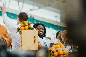 Football players enjoying oranges on the sidelines during a game at Hard Rock Stadium.