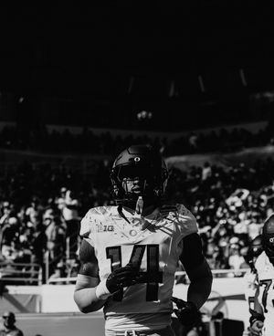Black and white photo of football players on the sideline during a game.