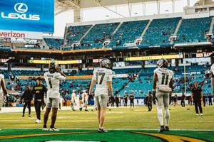 Wide angle view of Hard Rock Stadium field with players warming up before the game.