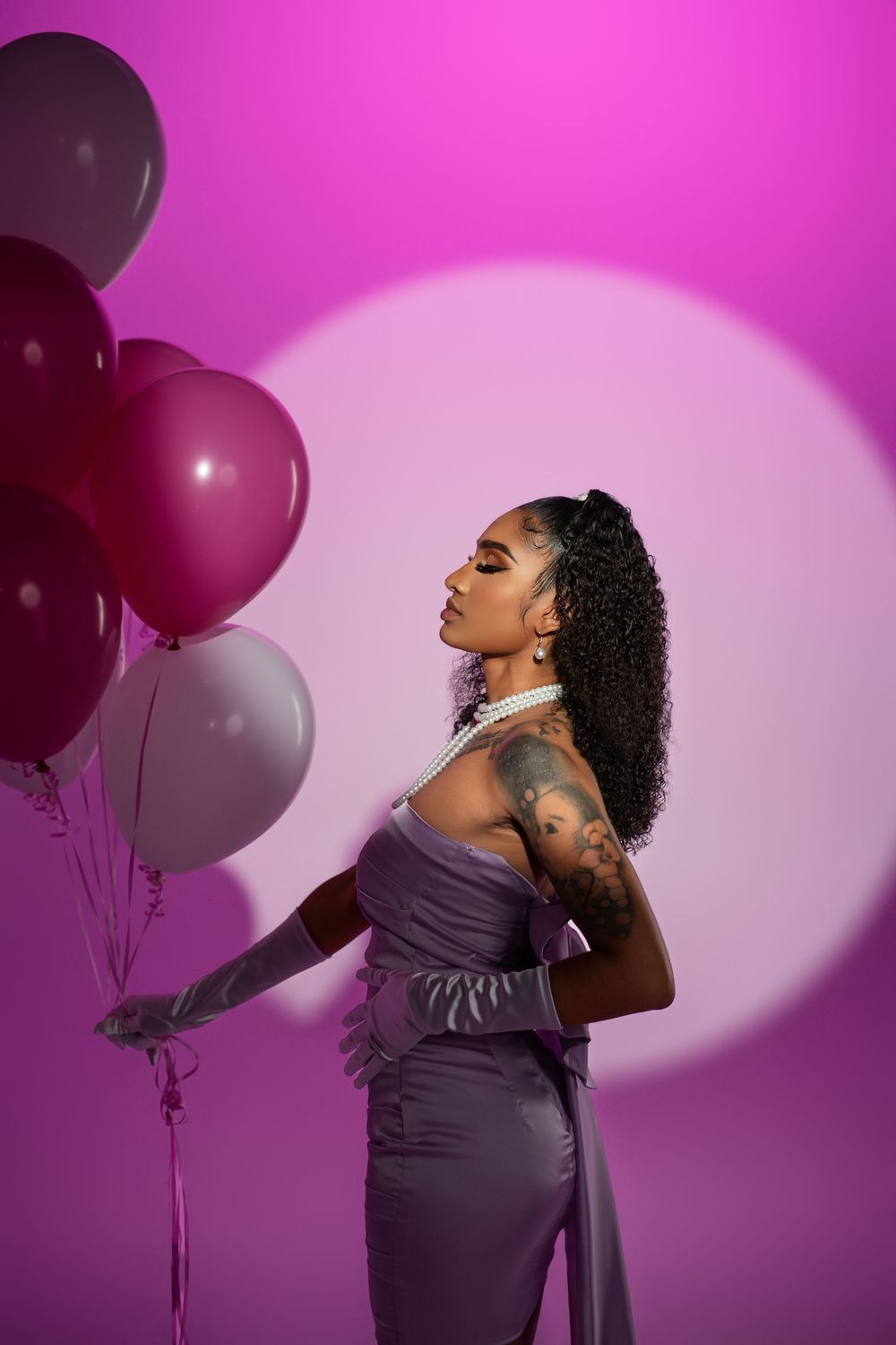 Dramatic fashion poses captured against pink backdrop with floating balloons.