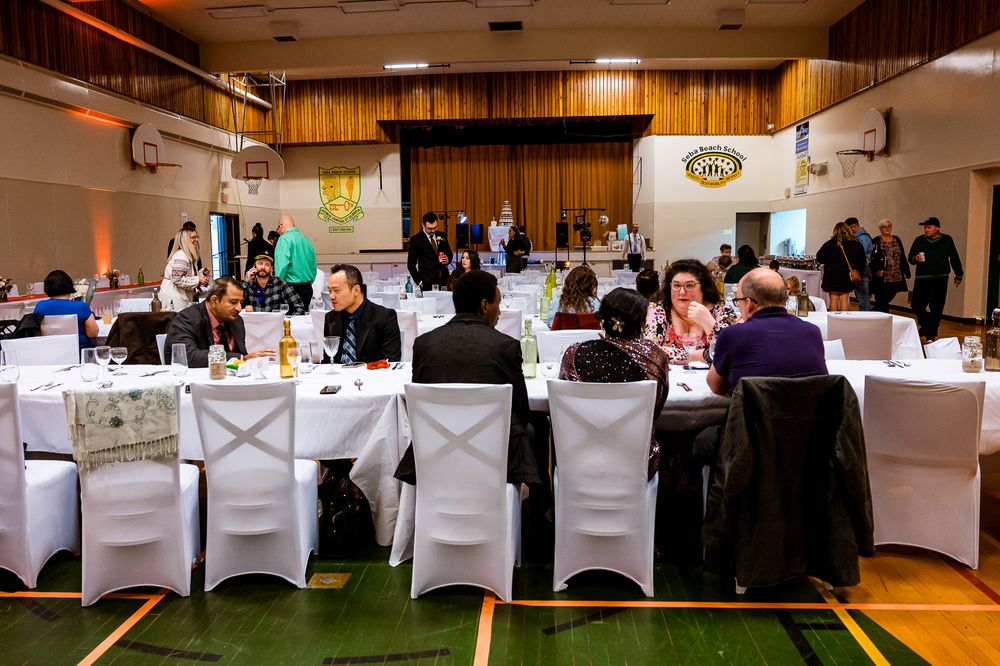 Wedding reception venue decorated with white tablecloths and chairs set up for an elegant indoor celebration.