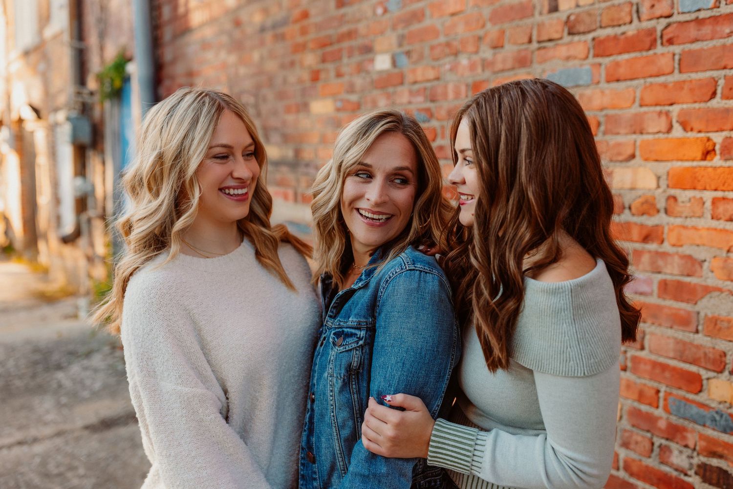 Casual family portrait against weathered white brick wall outdoors in Kansas City