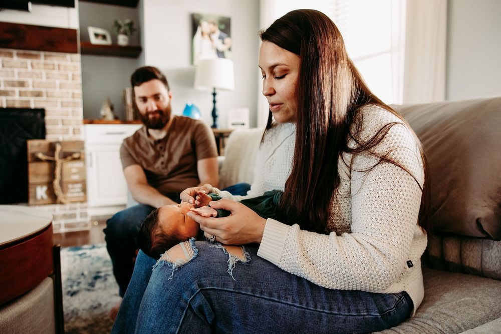 A couple relaxes on a couch in a modern living room while one plays video games.