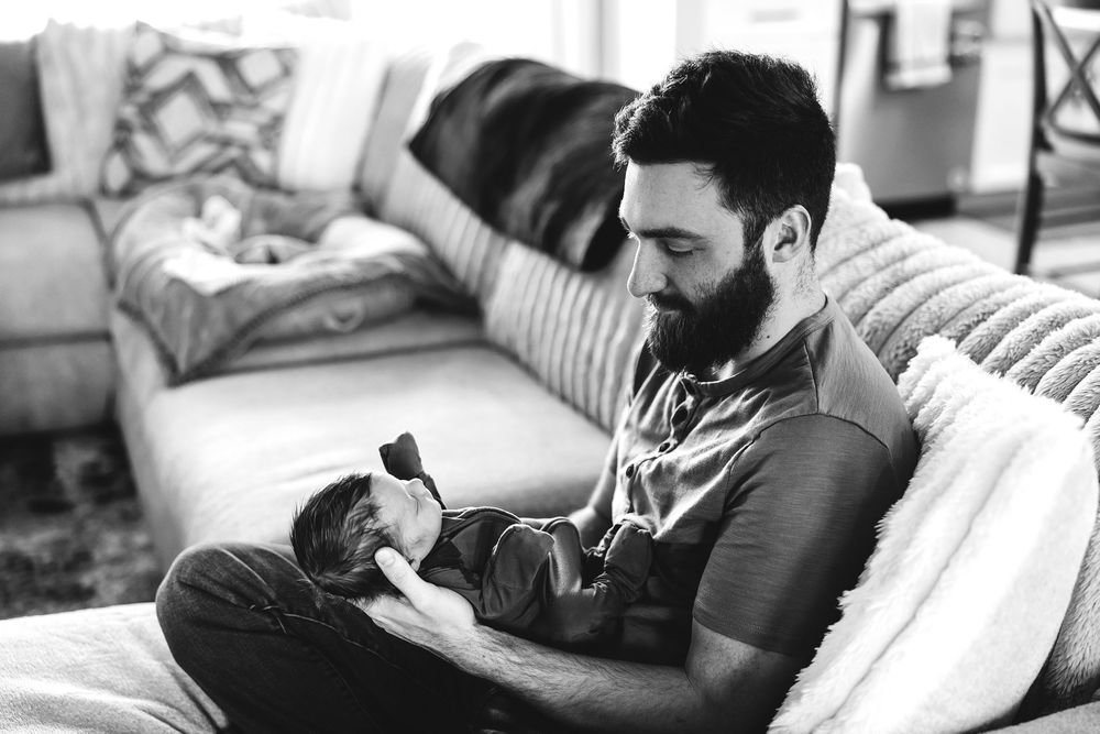 A couple relaxes together while reading books on a comfortable couch at home.