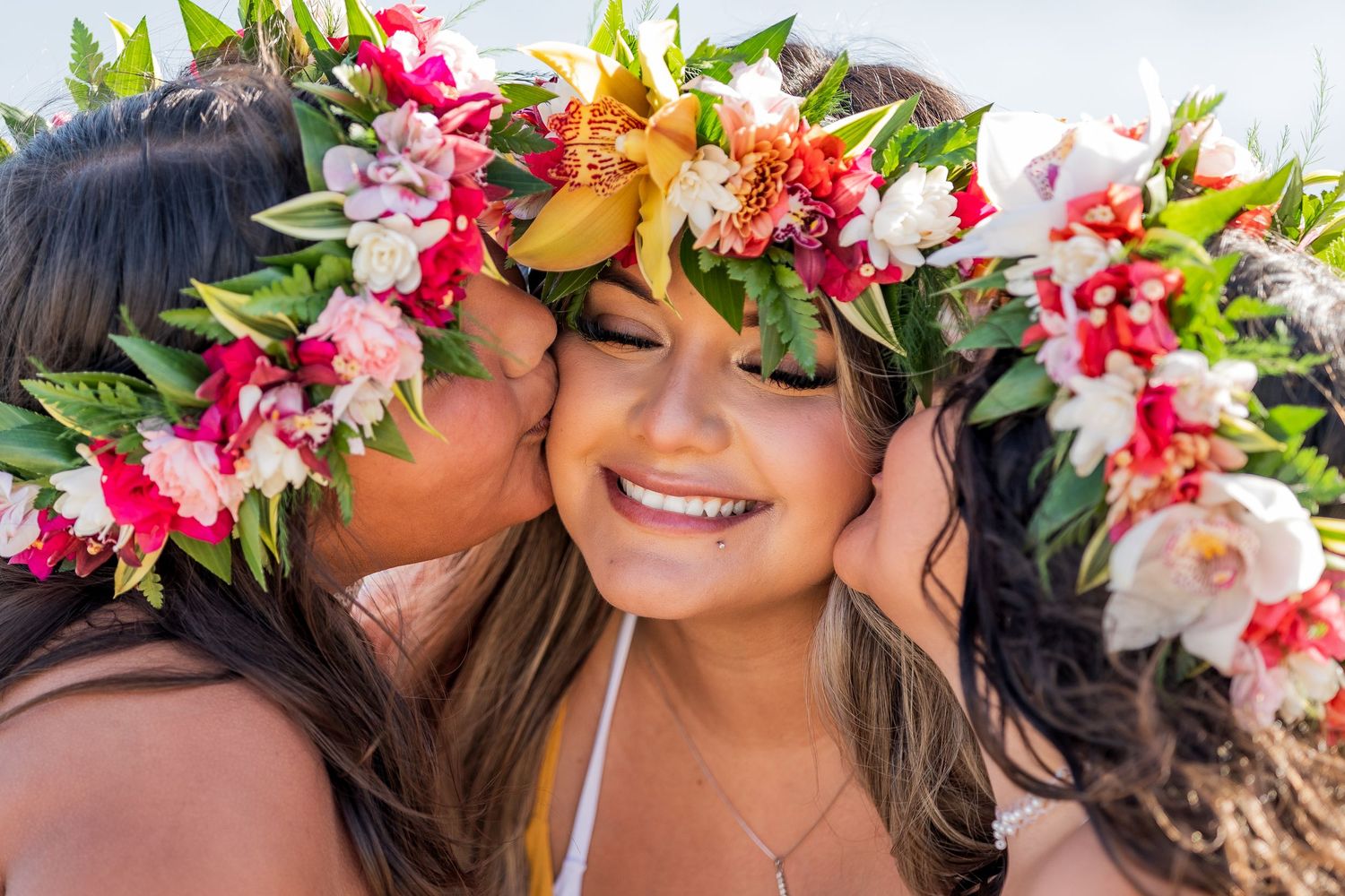 A collage of tropical flower leis and floral crowns with pink and white blooms against a natural background.