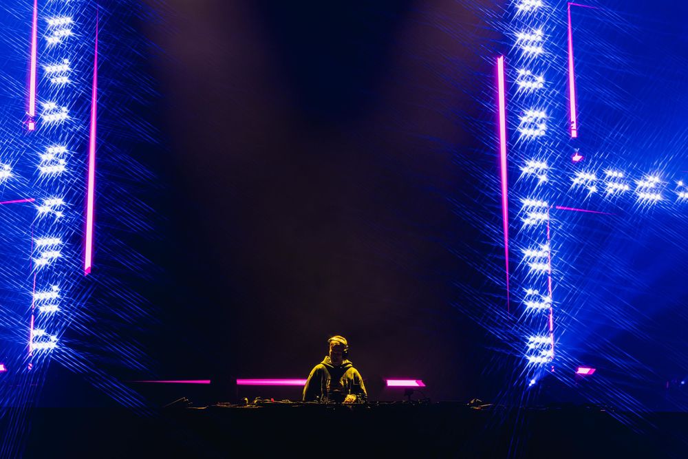 Concert stage illuminated with bright blue LED lights and fog effects creating a dramatic performance atmosphere.