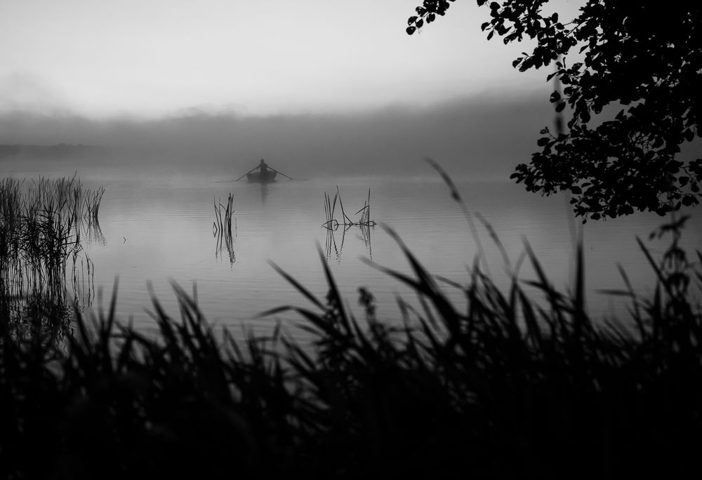 Stemningsfuldt kunstfotografi af en person der sejler på Tjele Langsø i tåge.