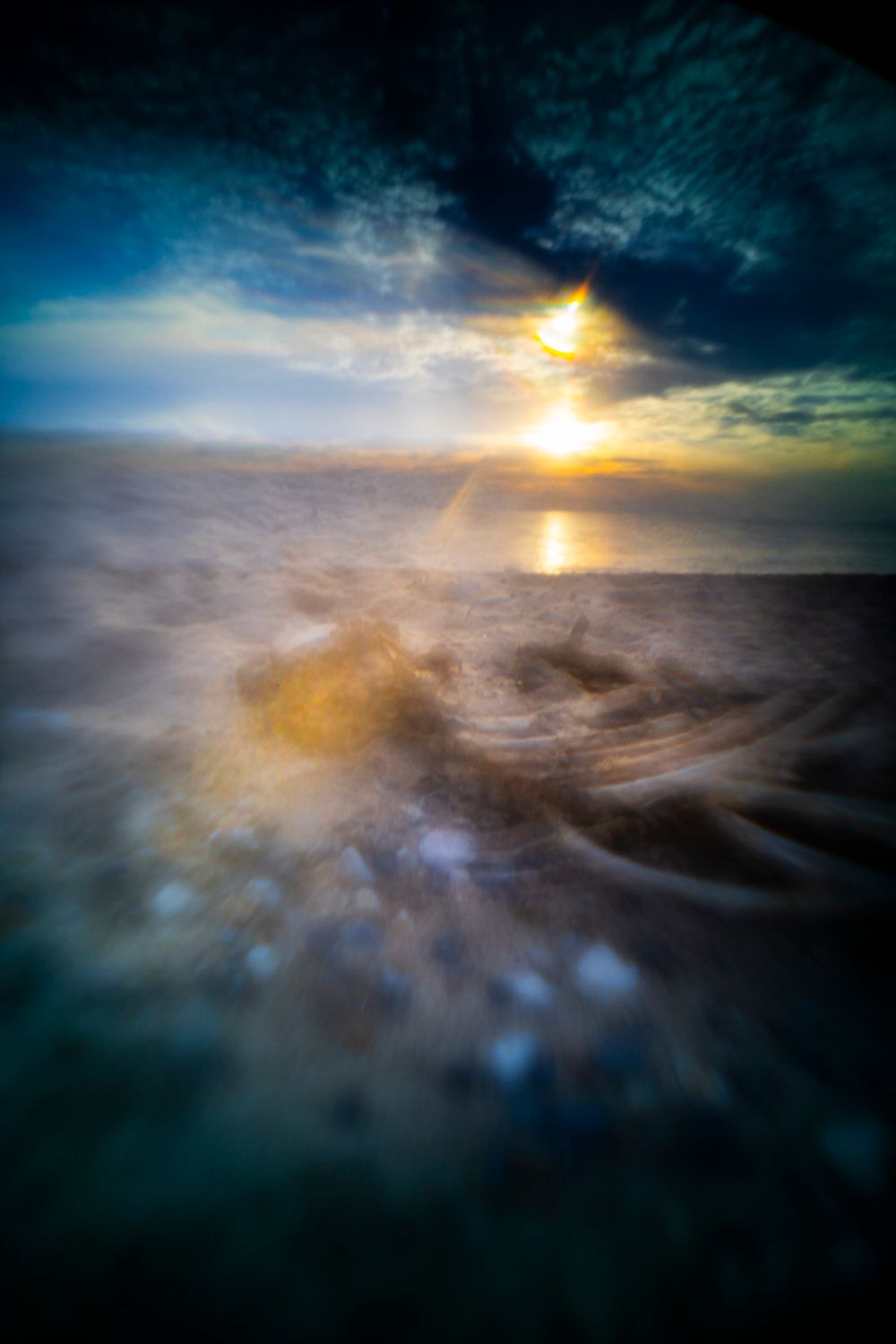 Mystisk og abstrakt kunstfotografi af en solnedgang ved Vesterhavet med en død fisk i forgrunden.