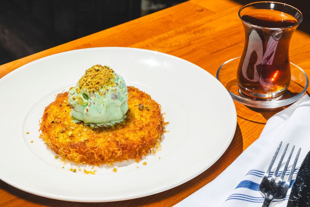 A close-up view of crispy breaded katsu cutlets topped with green garnish on white plates.