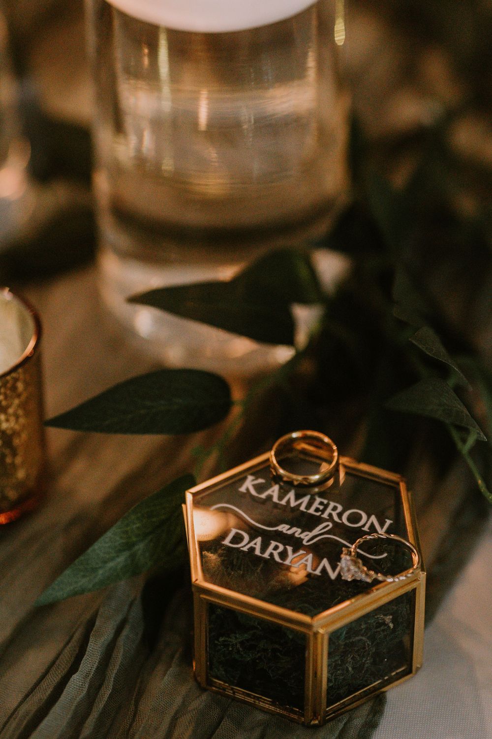 Gold-rimmed glass display boxes with names written on them in elegant party setting.